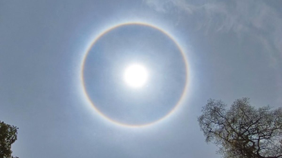 circular rainbow halo around the sun among blue sky and white clouds. Stock  Photo | Adobe Stock